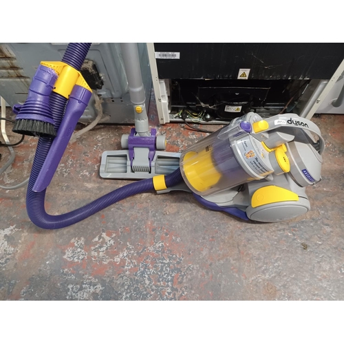 853 - A Dyson DC05 cylinder bagless vacuum cleaner with attachments