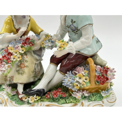 186 - A Sitzendorf hand painted porcelain flower seller group figurine - approx. 12.5cm high