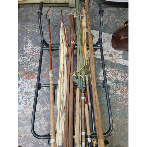 905 - A collection of fishing equipment to include metal luggage barrow, vintage split cane and bamboo rod... 