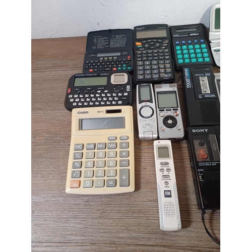 767 - A collection of handheld electronic devices to include pocket calculators, voice recorders, translat... 