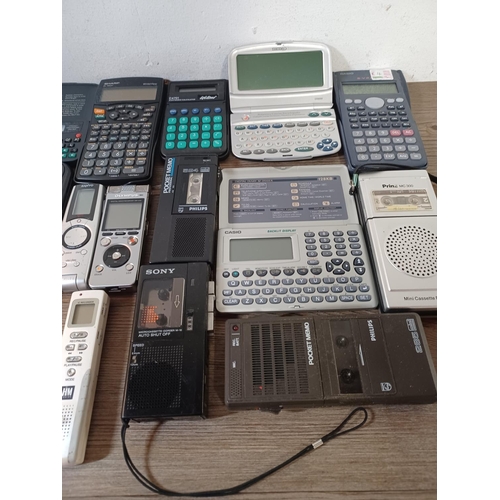 767 - A collection of handheld electronic devices to include pocket calculators, voice recorders, translat... 