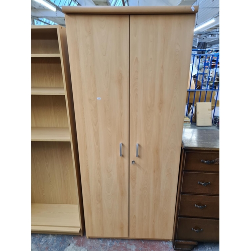 Three pieces of modern oak effect furniture, two bookcases and one two