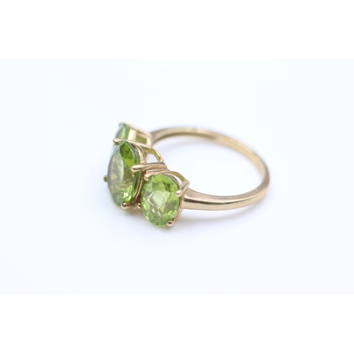 2008 - A 9ct gold peridot trilogy dress ring, size P - approx. gross weight 3.4 grams