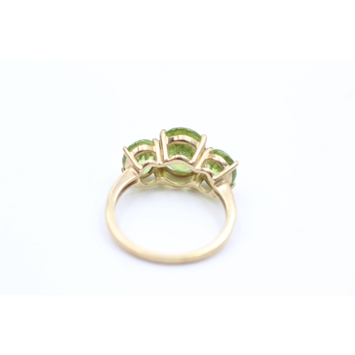 2008 - A 9ct gold peridot trilogy dress ring, size P - approx. gross weight 3.4 grams