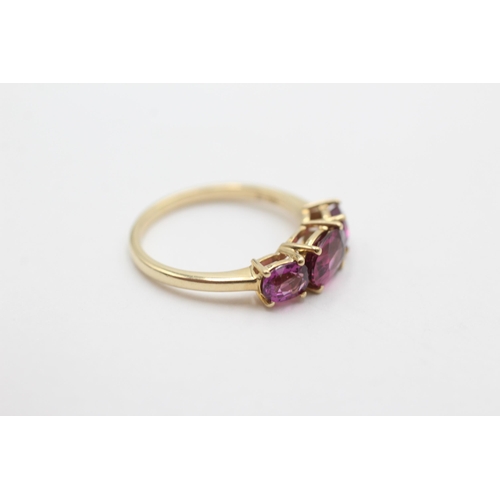 2010 - A 9ct gold garnet trilogy ring, size M - approx. gross weight 2.1 grams