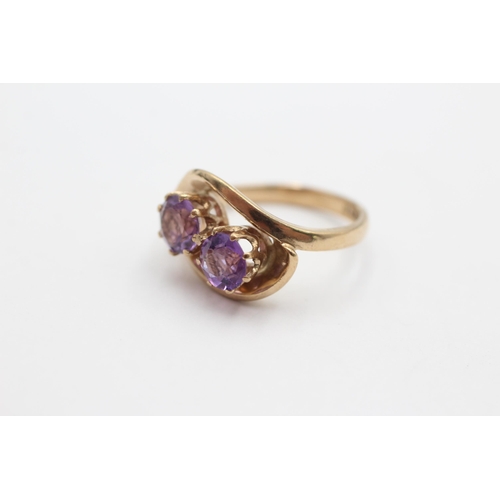 2037 - A 9ct gold amethyst twin stone twist setting dress ring, size N - approx. gross weight 4.1 grams