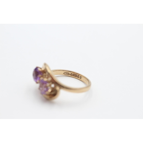 2037 - A 9ct gold amethyst twin stone twist setting dress ring, size N - approx. gross weight 4.1 grams