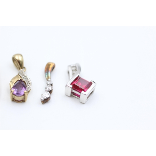 2051 - Four 9ct gold diamond set pendants to include synthethic ruby, amethyst etc. - approx. gross weight ... 