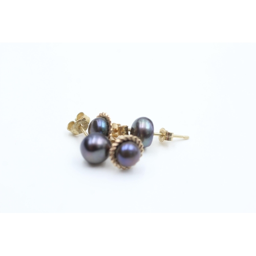 2084 - Two pairs of 9ct gold peacock pearl stud earrings - approx. gross weight 1.3 grams