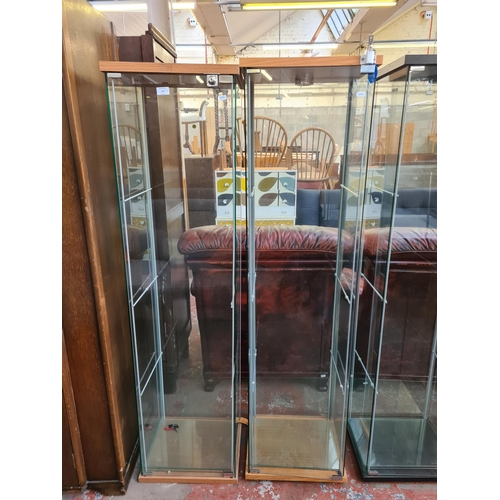 100 - Two modern beech effect and glass display cabinets with shelves - largest approx. 163cm high x 43cm ... 