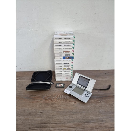 557 - A platinum silver Nintendo DS (NTR-001) original handheld games console with case and seventeen game... 