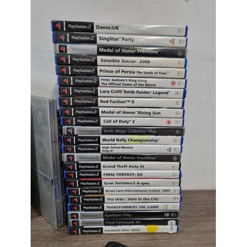 565 - Three silver Sony PlayStation 2 games consoles, one original and two slim with accessories and twent... 