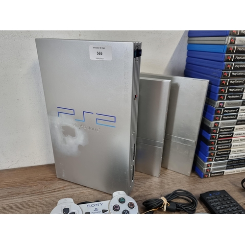 565 - Three silver Sony PlayStation 2 games consoles, one original and two slim with accessories and twent... 