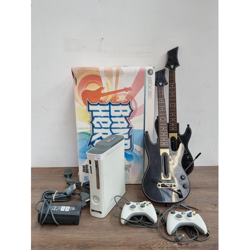 569 - A Microsoft Xbox 360 games console with boxed Band Hero games, accessories and two extra guitar cont... 