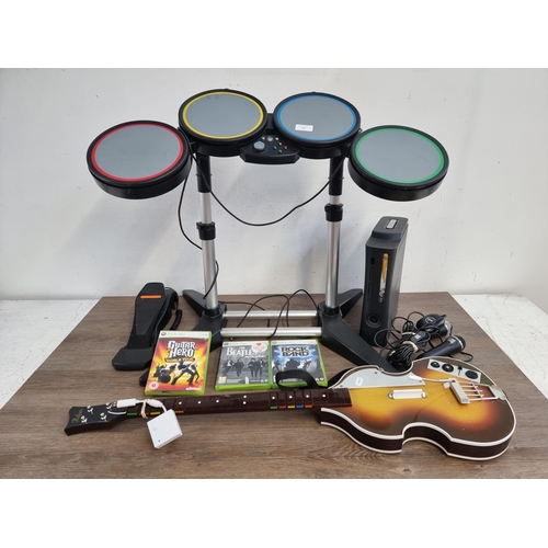 573 - A Microsoft Xbox 360 Elite games console with three games, Rock Band drum set, two microphones and o... 