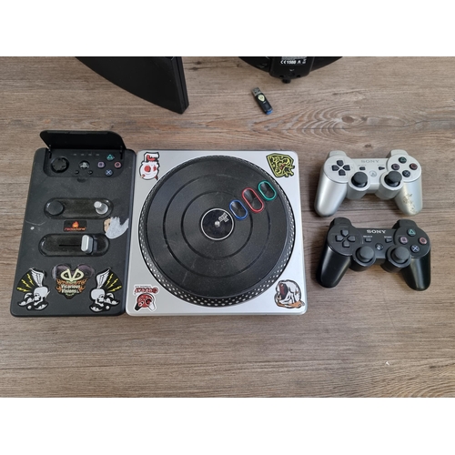 574 - A Sony PlayStation 3 slim games console with two DualShock 3 controllers, DJ HERO deck and Guitar He... 