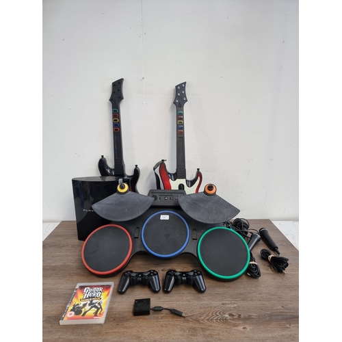 581 - A Sony PlayStation 3 games console with Rock Band drum set and two Guitar Hero guitars