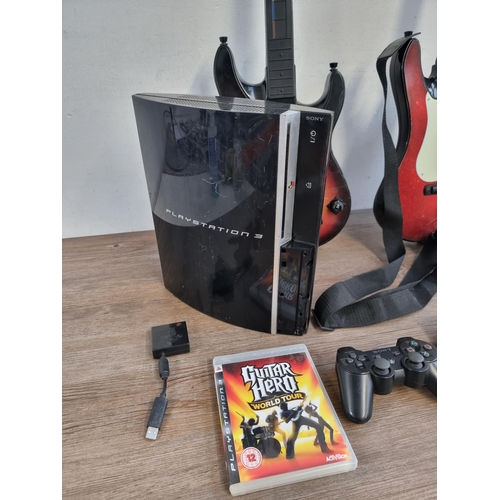 581 - A Sony PlayStation 3 games console with Rock Band drum set and two Guitar Hero guitars