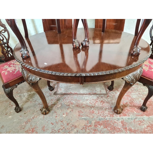 137 - A Georgian style mahogany wind out extending dining table with ball and claw supports, four dining c... 