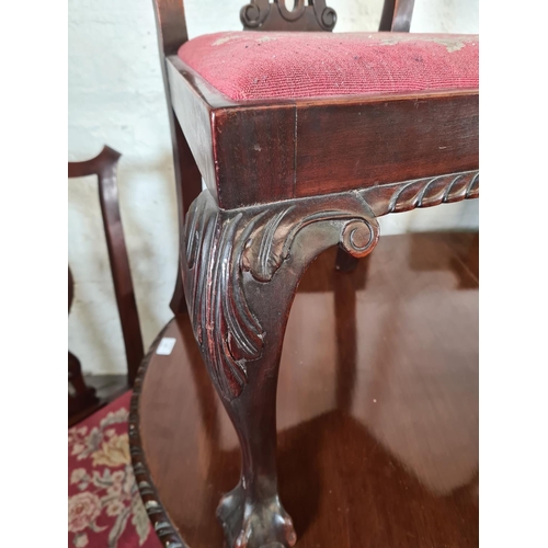 137 - A Georgian style mahogany wind out extending dining table with ball and claw supports, four dining c... 