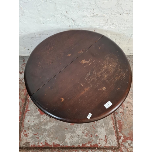 144 - An Ercol dark elm and beech drop leaf gate leg circular side table - approx. 47cm high x 61cm diamet... 