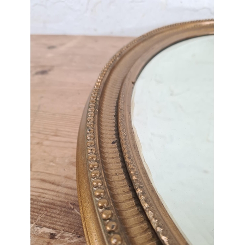 219 - A Regency style gilt framed bevelled edge oval wall mirror - approx. 52cm high x 41cm wide