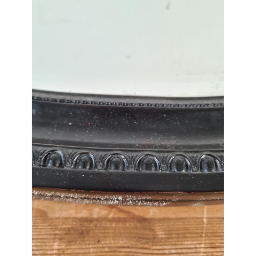 239 - A Regency style black framed bevelled edge oval wall mirror - approx. 87cm wide x 62cm high