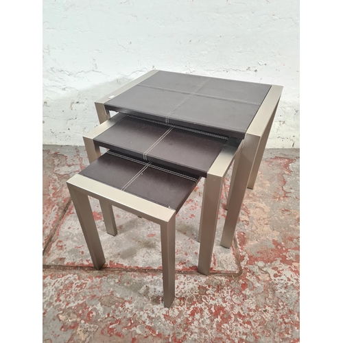 98 - A modern brushed steel and brown leatherette nest of three tables