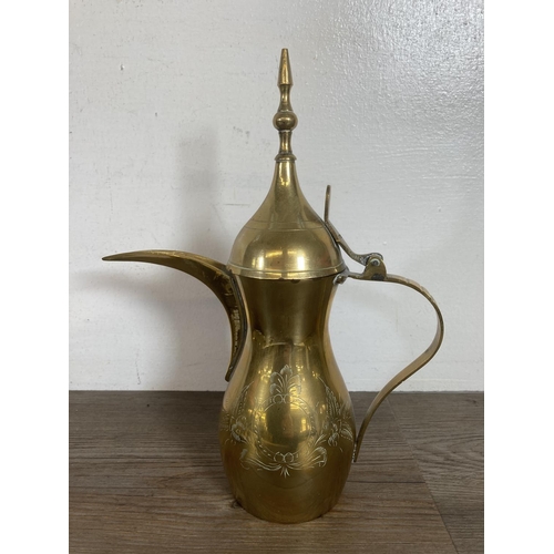 373 - A collection of brassware to include wooden handled bell, coffee pot etc.