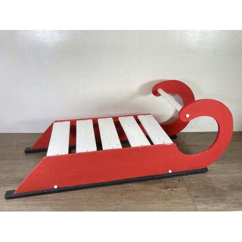 481 - A red and white painted wooden sledge - approx. 37cm high x 100cm long x 35cm deep