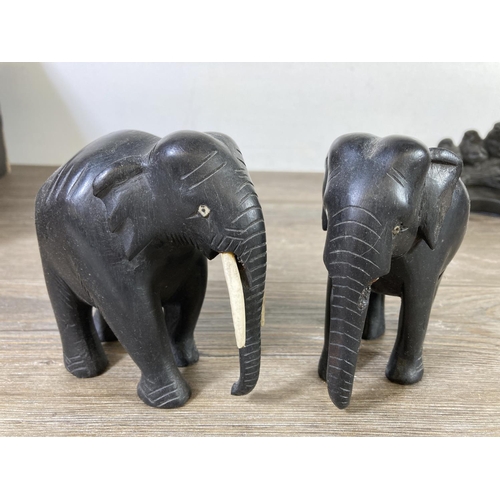 518 - Ten figurines comprising four carved ebony elephants, four carved hardwood elephants, one Priory Cas... 