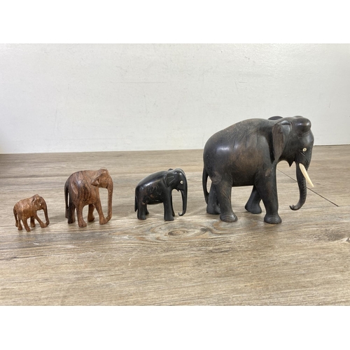 518 - Ten figurines comprising four carved ebony elephants, four carved hardwood elephants, one Priory Cas... 