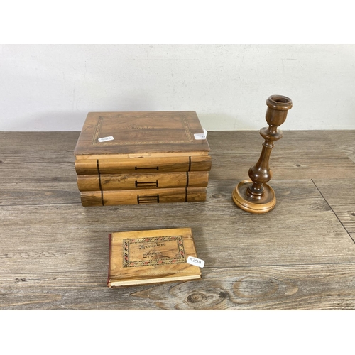 525 - Three early 20th century Jerusalem olive wood items, 20cm candlestick, pressed flowers book and puzz... 