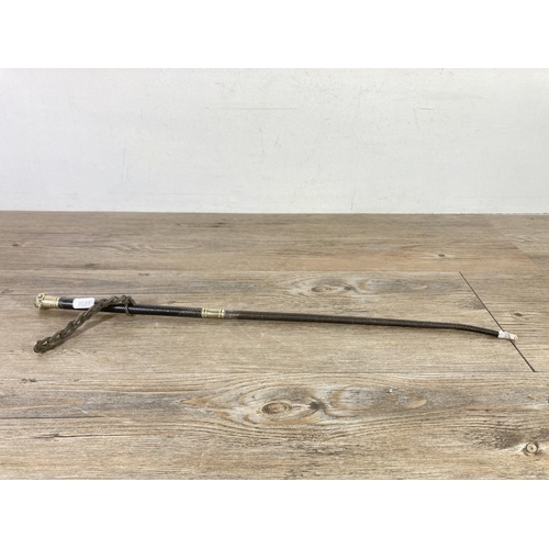 543 - An early 20th century leather and white metal riding crop - approx. 57cm long