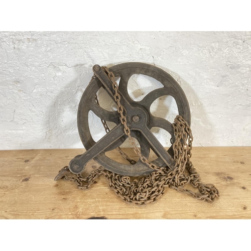 553 - A late 19th/early 20th century cast iron pulley wheel and chain - approx. 55cm high x 45cm wide