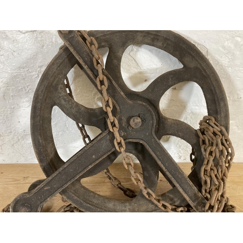 553 - A late 19th/early 20th century cast iron pulley wheel and chain - approx. 55cm high x 45cm wide