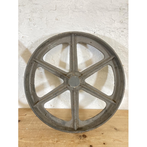 554 - Two late 19th/early 20th century cast iron mill wheels - largest approx. 52cm diameter