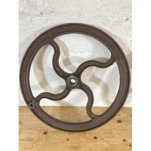 554 - Two late 19th/early 20th century cast iron mill wheels - largest approx. 52cm diameter