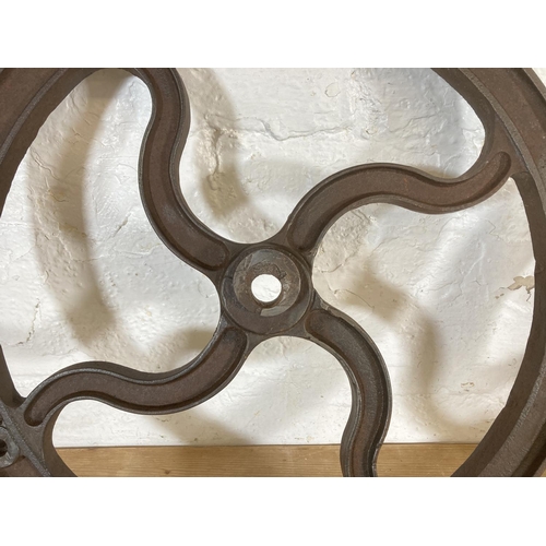 554 - Two late 19th/early 20th century cast iron mill wheels - largest approx. 52cm diameter