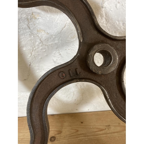 554 - Two late 19th/early 20th century cast iron mill wheels - largest approx. 52cm diameter