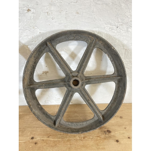 554 - Two late 19th/early 20th century cast iron mill wheels - largest approx. 52cm diameter