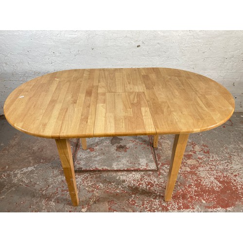 169 - A modern beech oval extending dining table and four dining chairs - approx. 134cm extended