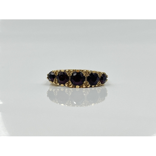 1124 - A hallmarked Birmingham 9ct gold garnet five stone ring, dated 1977, size L½ - approx. gross weight ... 