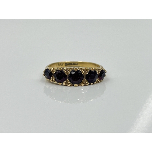 1124 - A hallmarked Birmingham 9ct gold garnet five stone ring, dated 1977, size L½ - approx. gross weight ... 