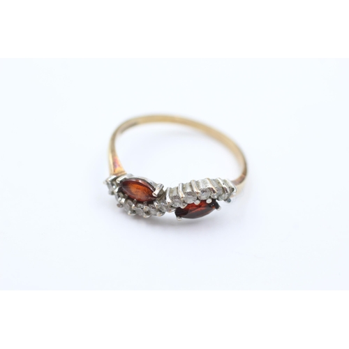 1052 - A 9ct gold garnet and clear gemstone stylised twist setting ring, size Q - approx. gross weight 2 gr... 