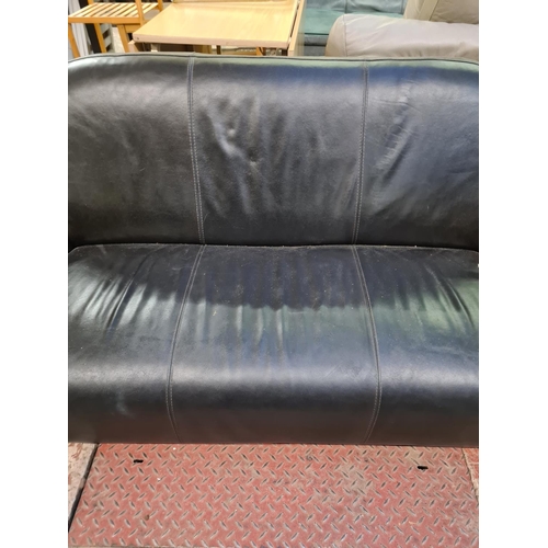 26 - A modern black leather three seater sofa