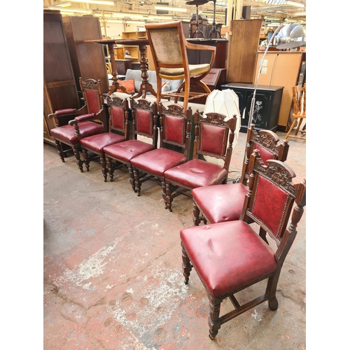 62 - A set of seven late Victorian carved oak and red vinyl dining chairs