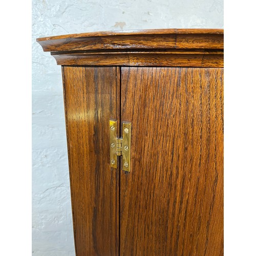 34 - A George III style oak wall mountable corner cabinet with brass 'H' hinges - approx. 90cm high x 67c... 