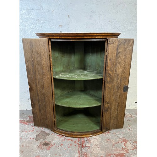 34 - A George III style oak wall mountable corner cabinet with brass 'H' hinges - approx. 90cm high x 67c... 