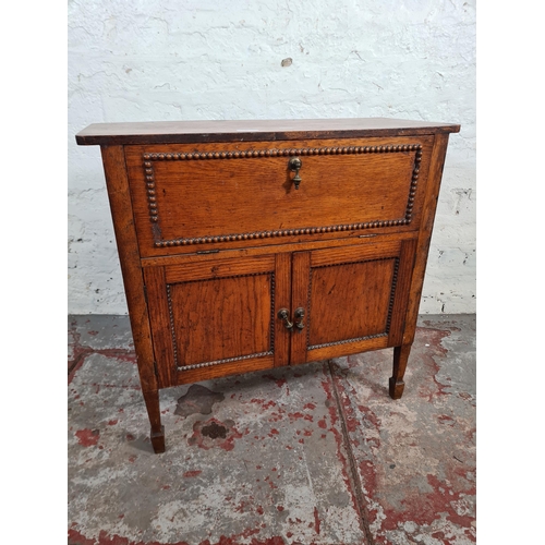 117 - A 1930s oak cabinet with fall front, two lower cupboard doors and beaded decoration - approx. 66cm h... 